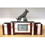 An Art Deco mantel clock garniture, with spelter alsatian over a marble clad rectangular case,