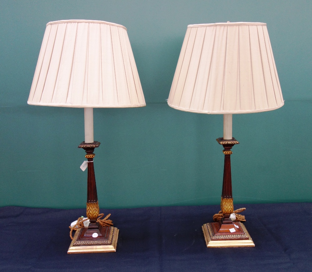 A pair of Georgian style mahogany table lamps, with fluted and gilt fluted columns on square bases,