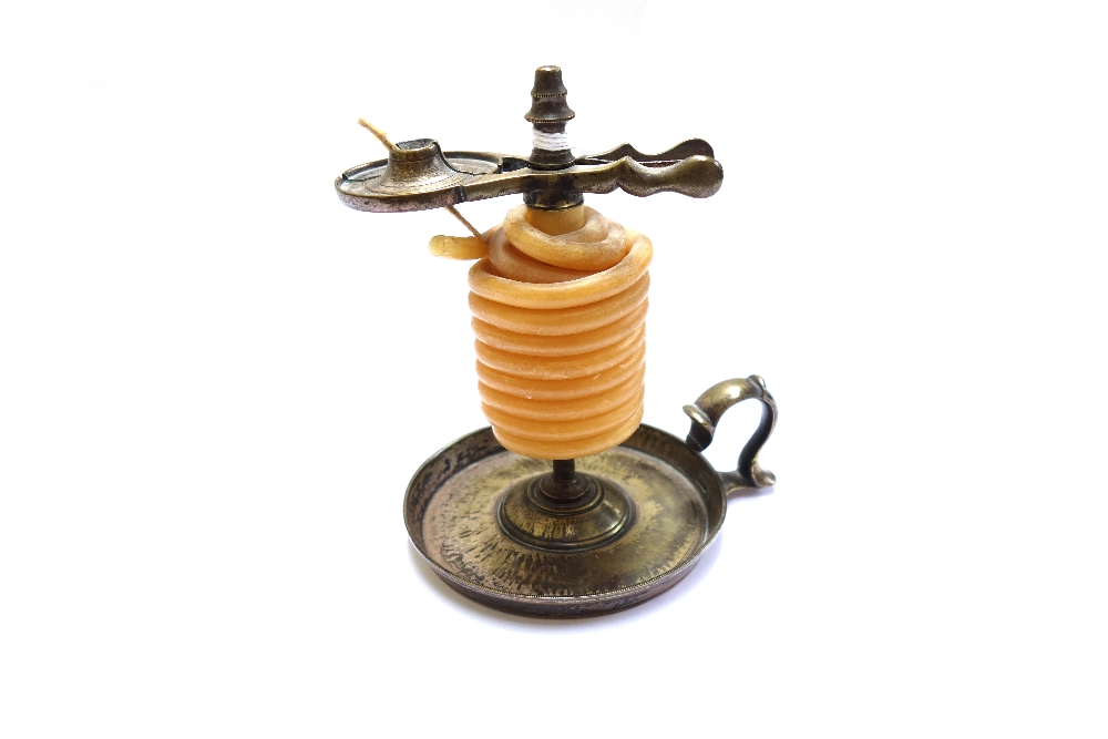 A Georgian brass wax jack, with scissor action and looped handle, on a circular base, 12cm high.