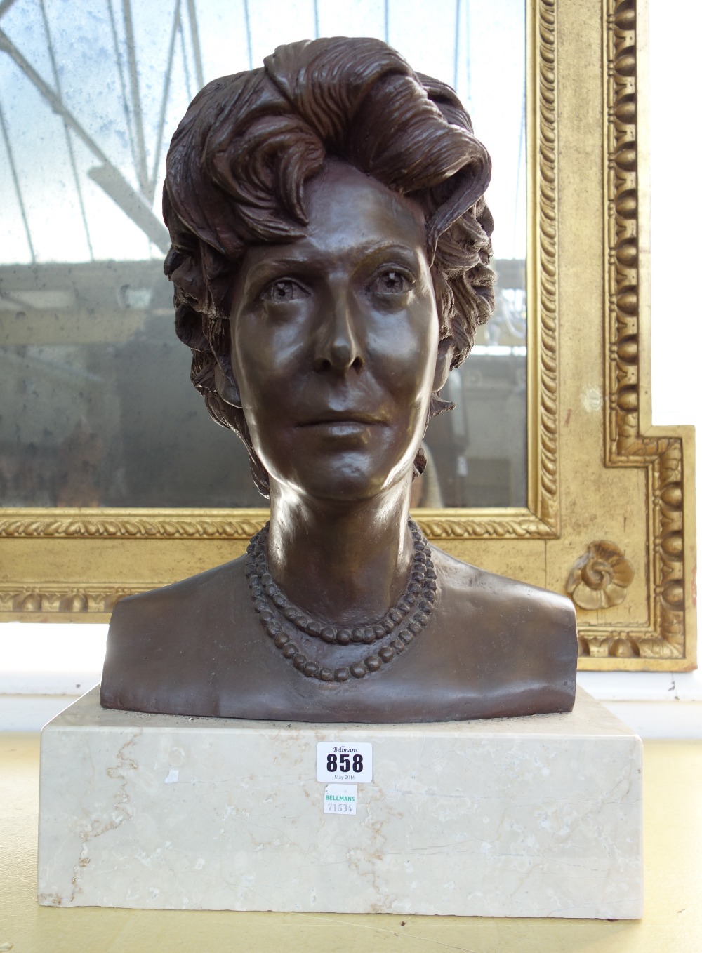 A bronze portrait bust depicting a female subject, signed and dated March 1989 to the rear,