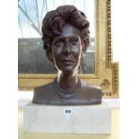 A bronze portrait bust depicting a female subject, signed and dated March 1989 to the rear,