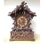 A Black Forest carved walnut or Linden wood mantel clock, late 19th century,