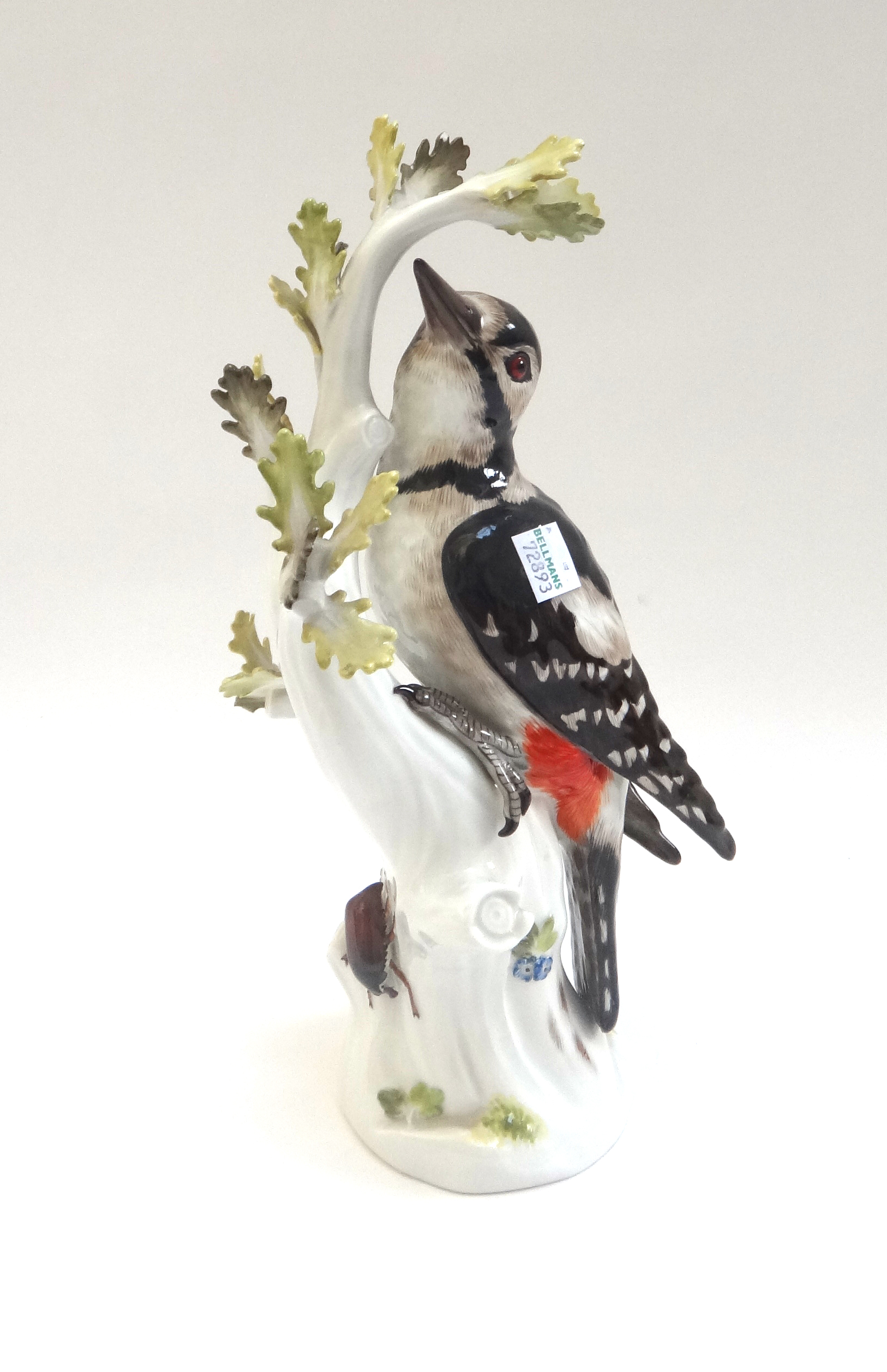 A Meissen porcelain great spotted woodpecker, early 20th century, modelled on a leafy branch,