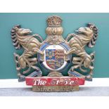 A wood and sheet metal mounted coat of arms titled 'The Stables Since 1854' with painted decoration,