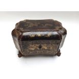 An early Victorian black lacquer chinoiserie decorated tea caddy of shaped compressed octagonal