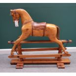 A pine rocking horse, early 20th century, paint traces but with a stripped and polished finish,