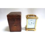 A 20th century French brass cased carriage clock with white enamel dial and Roman numerals,