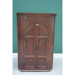 A George III mahogany hanging corner cupboard, with pair of arch top panel doors, 95cm wide.