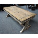 A 17th century style limed oak refectory table, on pierced trestle end standards,