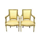 A pair of Louis XVI style parcel gilt off-white fauteuils,