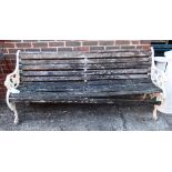 An early 20th century white painted cast iron bench with beast head finials, on scroll feet,