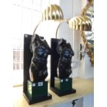 A pair of modern figural table lamps, each with an ebonised male torso atop a faux malachite plinth,