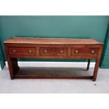 A George III oak dresser base, with three frieze drawers and enclosed panel sides,