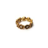 A gold and diamond set full eternity ring, designed as a row of flowerheads,