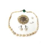 A single row necklace of graduated cultured pearls, on a gold and emerald bead clasp,