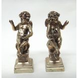 A pair of European models of seated cherubs, each raised on a square base, detailed 800,