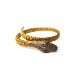 A gold and diamond set bracelet, designed as a coiled snake,