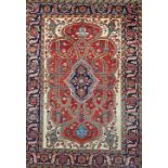 A Heriz carpet, Persian, the shaped madder field with an indigo medallion,