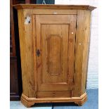 A 19th century Continental stripped pine single door armoire, with canted sides on bracket feet,