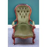 A Victorian carved walnut framed open armchair with serpentine seat on scroll supports.