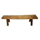 Paolo Gucci; a 19th century oak pig bench, the rectangular slab top on four staked supports,