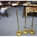 A set of three 20th century floor standing brass anglepoise reading lamps.