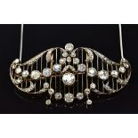 A diamond set brooch cum necklace front, in a scroll and foliate pierced openwork undulating design,