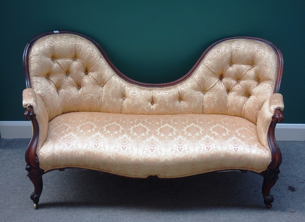 A Victorian rosewood framed double spoon back sofa, with serpentine seat on cabriole supports,