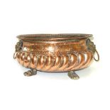 A 17th century Dutch repoussé copper and brass mounted oval jardiniere with mask ring handles and