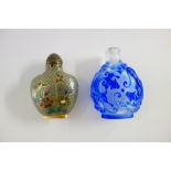 A Chinese blue overlay glass snuff bottle, 20th century, decorated with dragons and bats, 6cm.