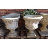 A set of eleven reconstituted stone garden urns, with semi-fluted bodies and spiral fluted socle,