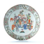 A Chinese famille-rose circular dish, circa 1900, painted with figures at leisure amongst tables,