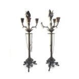 A pair of bronze three branch candelabra, late 19th/early 20th century, each with a stork surmount,