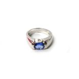 A white gold, tanzanite and diamond set three stone ring, mounted with an oval cut tanzanite,