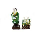 A Chinese famille-verte biscuit figure of a man, probably Kangxi, standing holding lotus flowers,