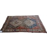 A Ghasghai rug, Persian, the brown field with two bold stepped ivory medallions supporting chickens,