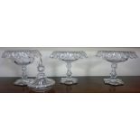 A set of three late Victorian glass comports, facet cut, on hourglass stems and hexagonal bases,