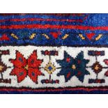 A North West Persian rug, the madder field with a sage medallion, indigo spandrels,