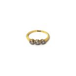 A gold and diamond three stone ring, collet set with a row of cushion shaped diamonds,