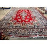 A Kerman carpet, Persian, the crimson field with an indigo medallion,