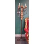 A pair of wrought iron and painted timber five light standing candelabra,