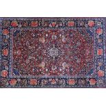 A Kashan rug, Persian, the madder floral spray field with an indigo medallion, matching spandrels,