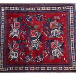 An Afshar rug, South Persian, the madder field with five bunches of roses, an ivory flower border,