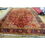 An Heriz carpet, Persian, the dark madder field with a bold central rosette medallion,