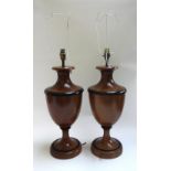 A pair of modern fruitwood table lamps, each of urn form with ebonised banding, on a circular foot,