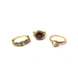 A gold, garnet and diamond set cluster ring, claw set with the cushion shaped garnet to the centre,