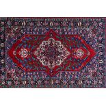 A Mahal rug, Persian, the shaped madder field with an ivory medallion, floral branches,