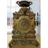 A French gilt bronze mantel clock, 19th century, with urn surmount, lion and Bacchus masks,