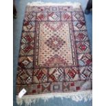 An Indian part silk rug, the field with stylized diamond design, complementary section border,