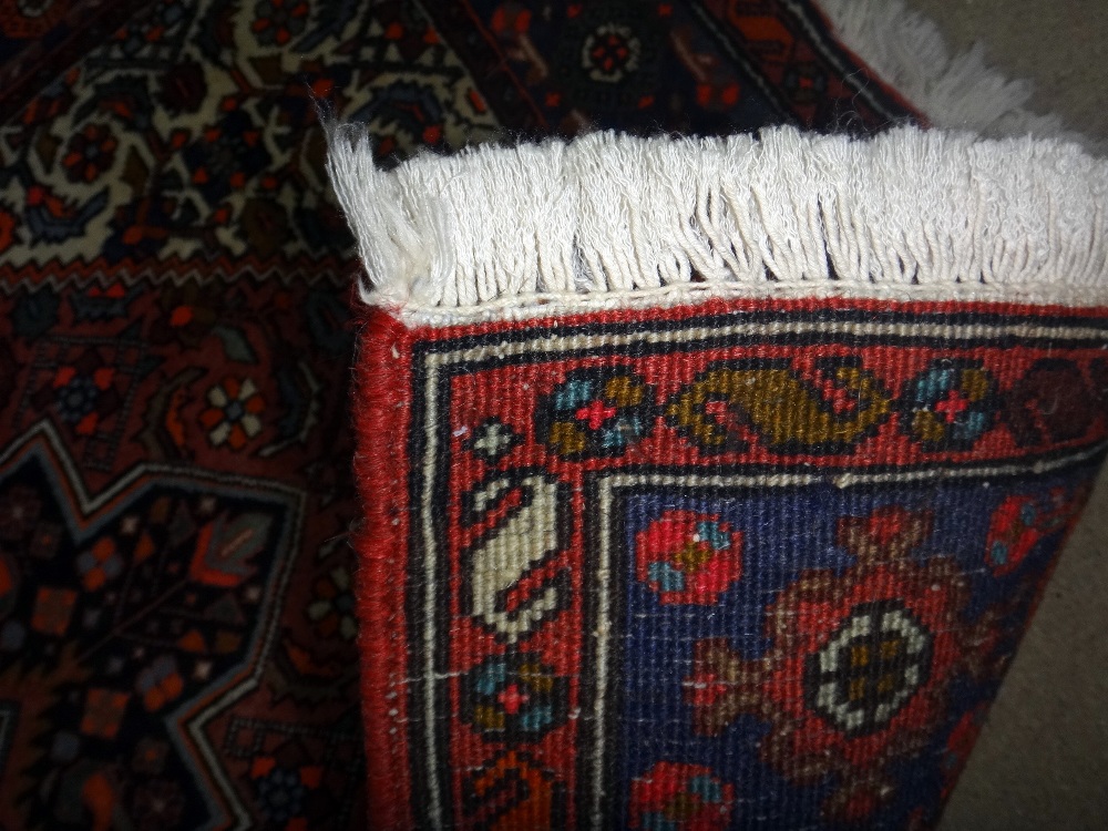 A Sarough rug, Persian, the madder floral field with stepped black medallion, ivory spandrels, - Image 7 of 8